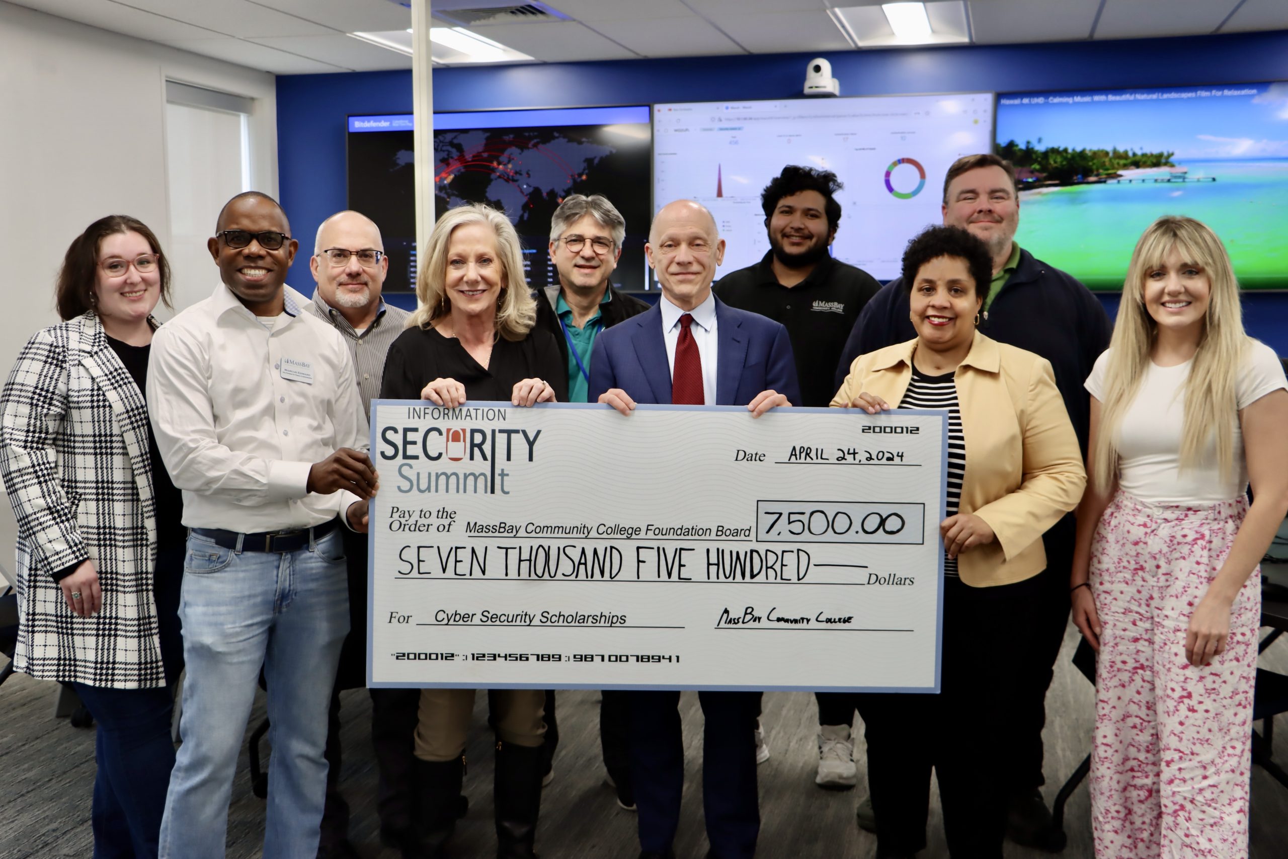 Framingham-based Towerwall presents MassBay Community College with a check for $7,500 from last year’s Cyber Security Summit which is for student scholarships. From left to right, Sydney Johnson, MassBay Alumni Relations & Volunteer Coordinator; Marcus Edward, MassBay Vice President for Administration & Finance; Michelle Drolet, CEO & Founder, Towerwall; Tony Sena, Professor and Chair of the MassBay Cybersecurity Department; David Podell, MassBay President; Manoj Yeddanapudi, MassBay Computer Science Lab Manager; Mishawn Davis-Eyene, Executive Director of Development; Michael Lyons, MassBay Assistant Vice President & Chief Information Officer; Jacquelyn Drolet, Cybersecurity Sales Consultant, Towerwall pose in the College’s new cyber range located on the Wellesley Hills campus, Wellesley Hills, MA, April 2024 (Photo/ MassBay Community College)